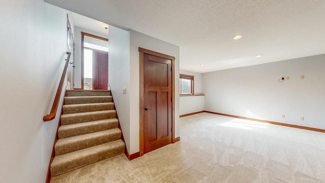 stairs with carpet and a textured ceiling