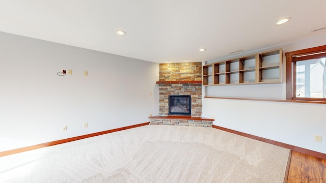 unfurnished living room with carpet and a fireplace