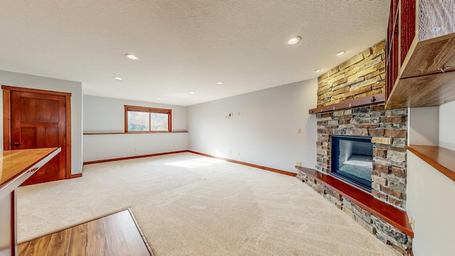 unfurnished living room with light carpet, a textured ceiling, and a fireplace