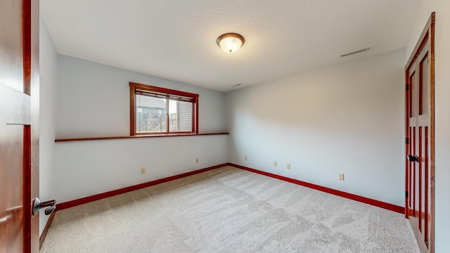 empty room featuring a textured ceiling and carpet floors