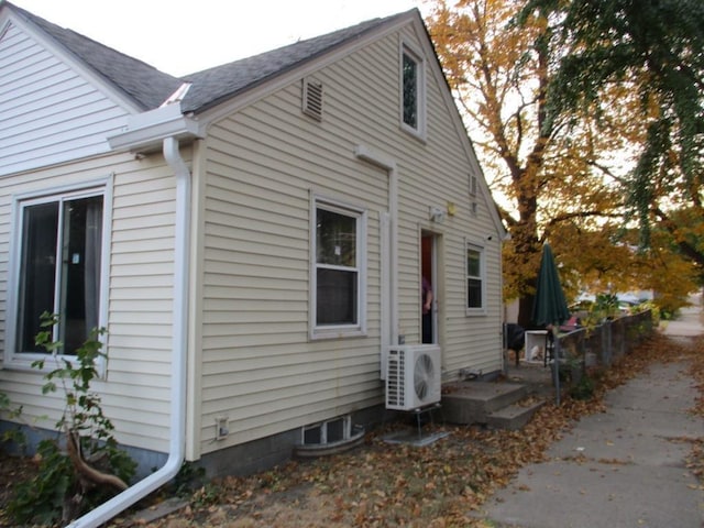 view of side of home with ac unit