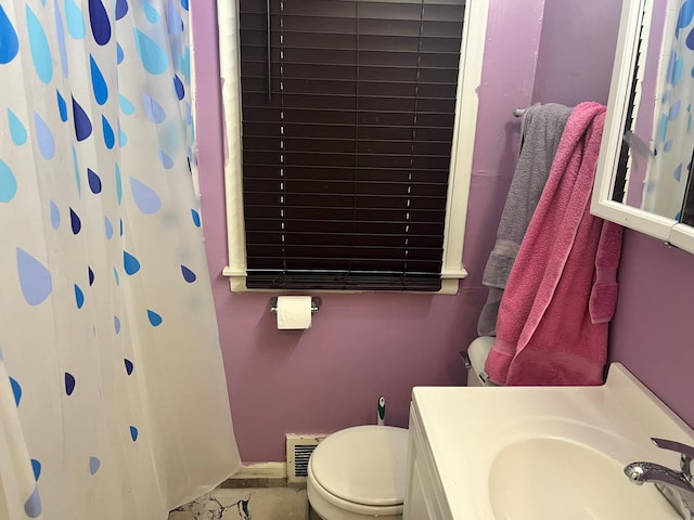 bathroom featuring sink, toilet, and a shower with shower curtain