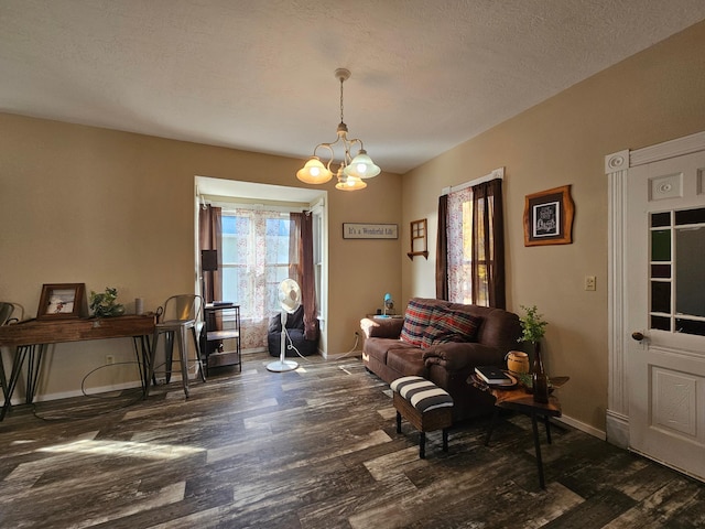 sitting room with dark hardwood / wood-style flooring, a chandelier, and a textured ceiling