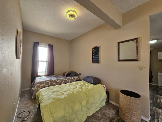 bedroom featuring beamed ceiling, a textured ceiling, and dark colored carpet