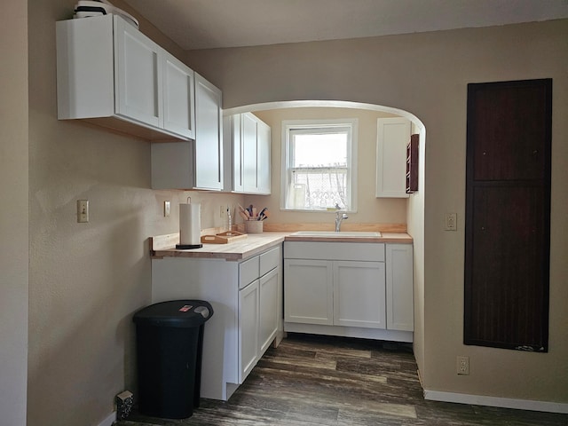 kitchen featuring white cabinetry, sink, and dark wood-type flooring