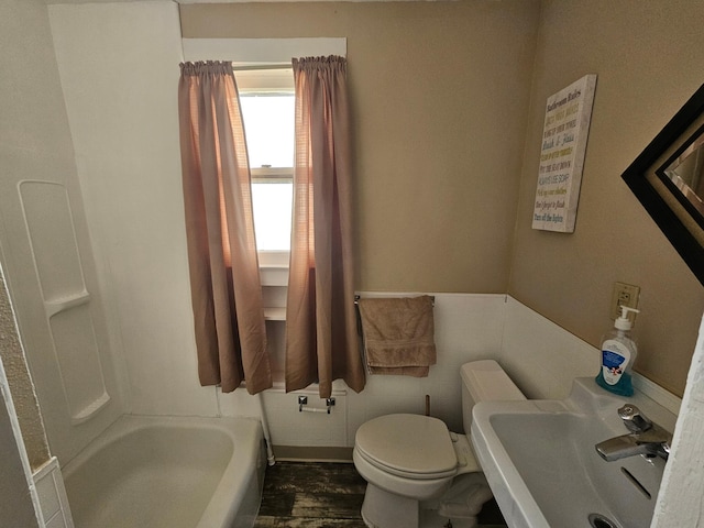 bathroom with a washtub, sink, and toilet