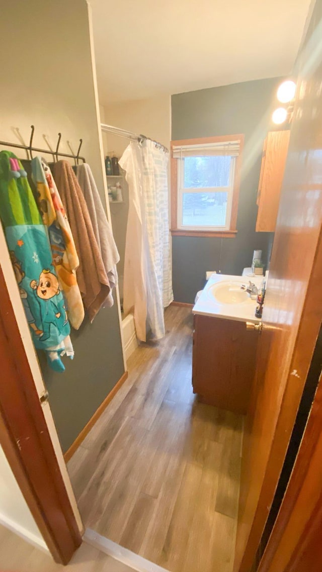 bathroom with shower / tub combo, vanity, and hardwood / wood-style flooring