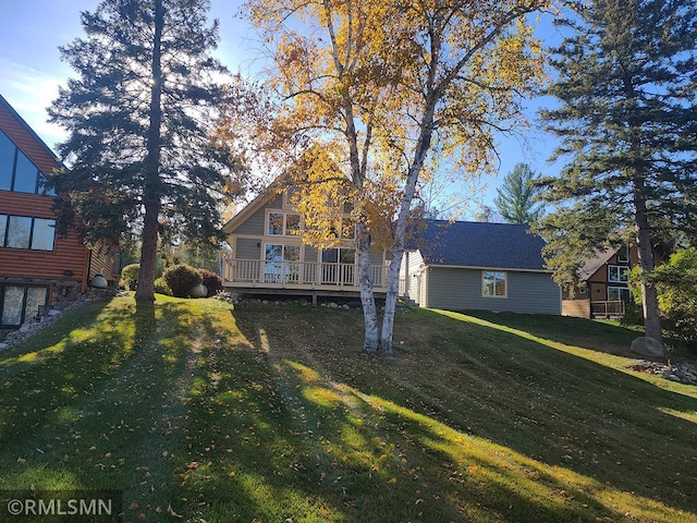 back of house with a deck and a lawn