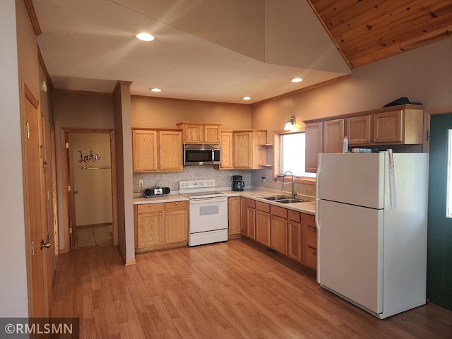 kitchen with white appliances, lofted ceiling, sink, and light wood-type flooring