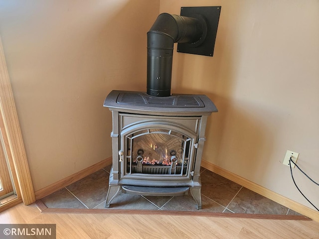 room details featuring a wood stove and hardwood / wood-style flooring