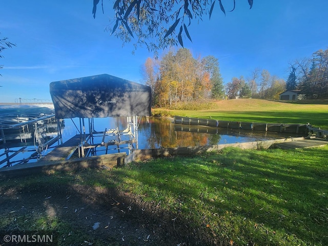 dock area featuring a water view and a lawn