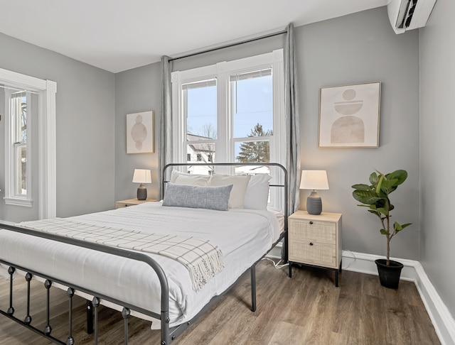 bedroom with wood-type flooring and a wall mounted air conditioner