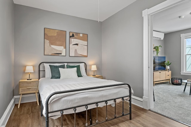 bedroom featuring a wall mounted air conditioner and hardwood / wood-style flooring