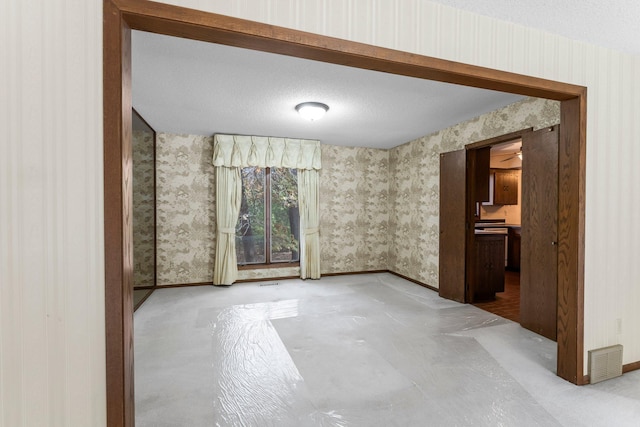 unfurnished room with a textured ceiling