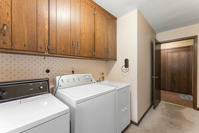 washroom with light carpet, cabinets, a textured ceiling, sink, and washer and clothes dryer