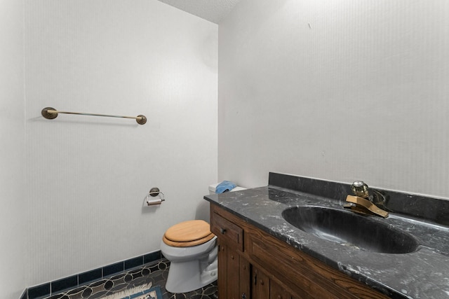 bathroom with vanity, toilet, tile patterned floors, and a textured ceiling