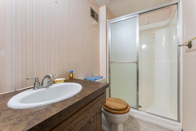 bathroom featuring vanity, a textured ceiling, walk in shower, and toilet