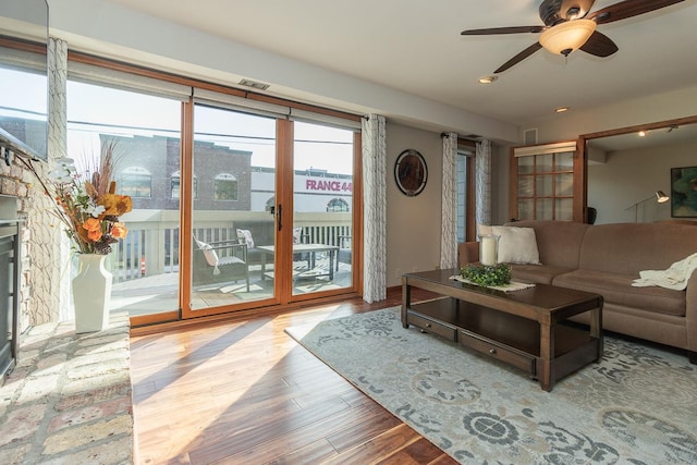 living room with ceiling fan and light wood-type flooring