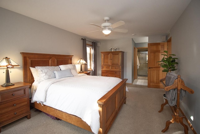 bedroom featuring ceiling fan, connected bathroom, and light colored carpet