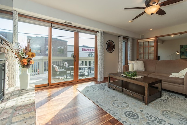 living area featuring a ceiling fan, visible vents, wood finished floors, and recessed lighting