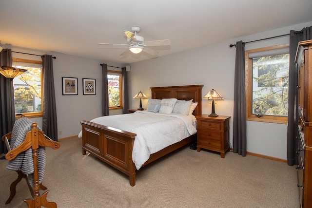 bedroom featuring light colored carpet, ceiling fan, and baseboards