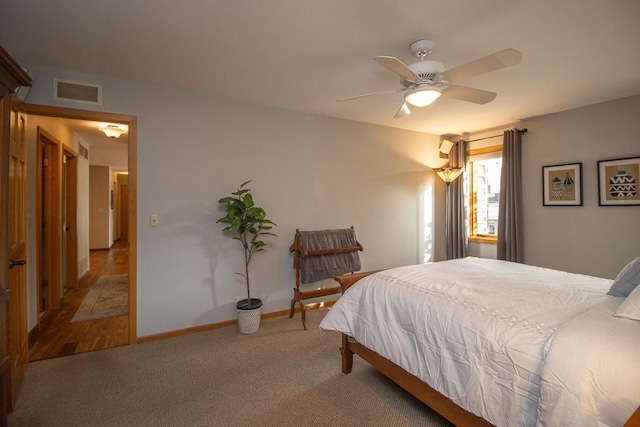 carpeted bedroom featuring ceiling fan, visible vents, and baseboards