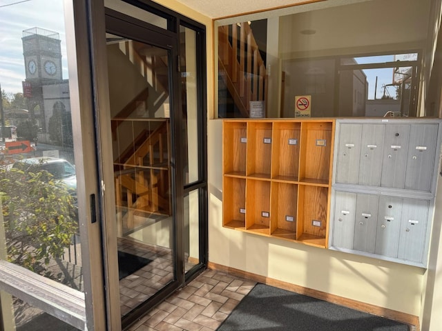 wine room featuring brick floor, baseboards, and mail area