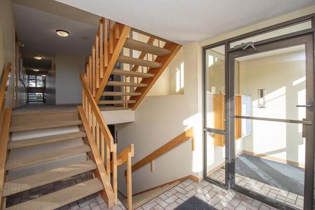 stairway with brick floor and baseboards