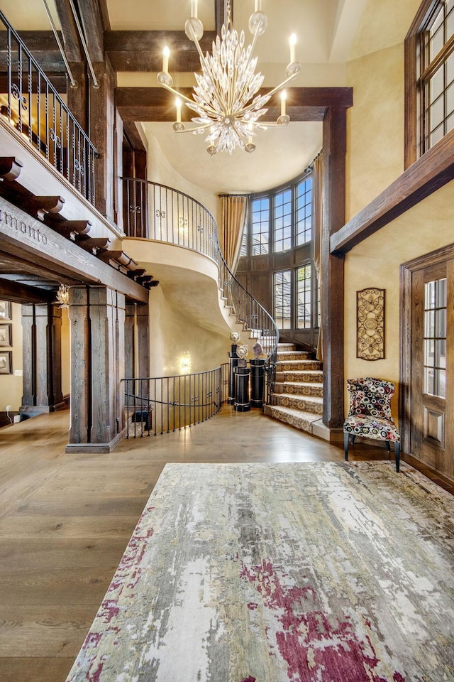 10675 Cavallo Rdg, Eden Prairie, MN 55347 - entryway featuring a towering ceiling, a chandelier, wood finished floors, and healthy amount of natural light