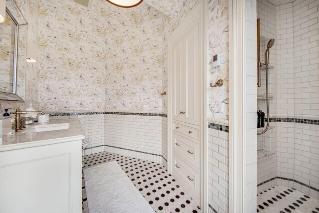 10675 Cavallo Rdg, Eden Prairie, MN 55347 - full bathroom with wallpapered walls, tiled shower, vanity, and a wainscoted wall
