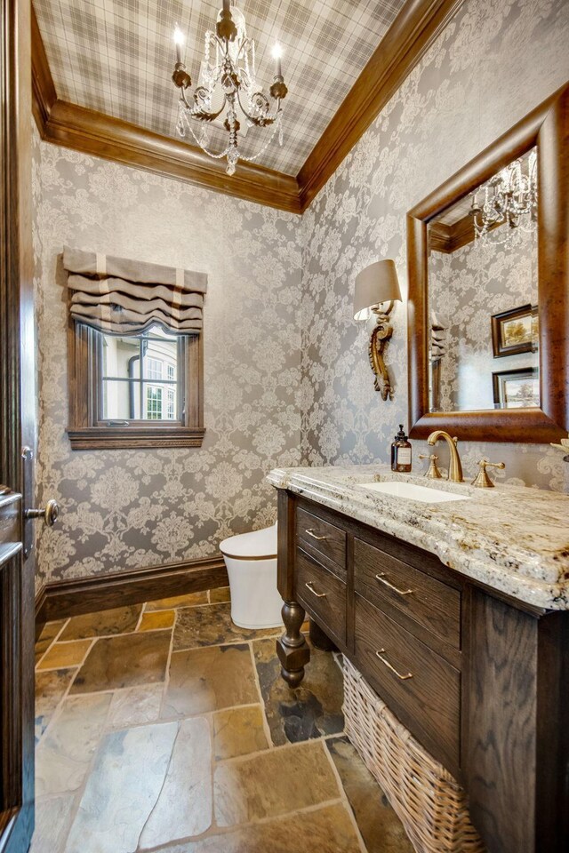 10675 Cavallo Rdg, Eden Prairie, MN 55347 - bathroom with crown molding, vanity, stone tile flooring, a chandelier, and wallpapered walls