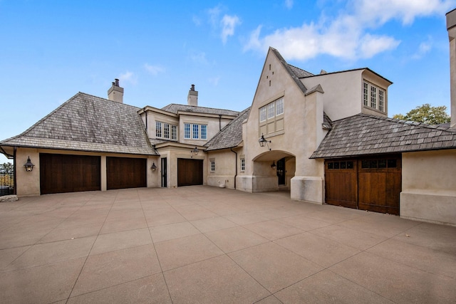 10675 Cavallo Rdg, Eden Prairie, MN 55347 - french country inspired facade with stucco siding, driveway, a garage, and a chimney