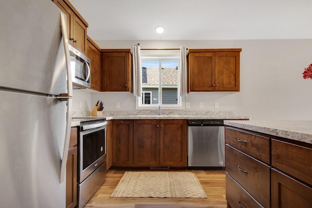 kitchen featuring sink, appliances with stainless steel finishes, and light hardwood / wood-style flooring