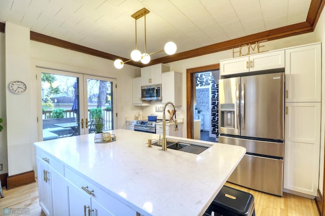 kitchen with french doors, white cabinetry, stainless steel appliances, light hardwood / wood-style flooring, and a center island with sink