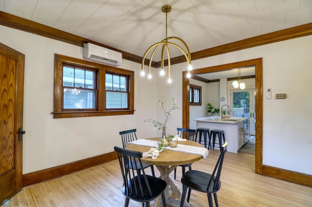 dining room featuring crown molding, an AC wall unit, sink, and light wood-type flooring