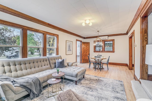 living room with light hardwood / wood-style floors, crown molding, a chandelier, and a wall unit AC