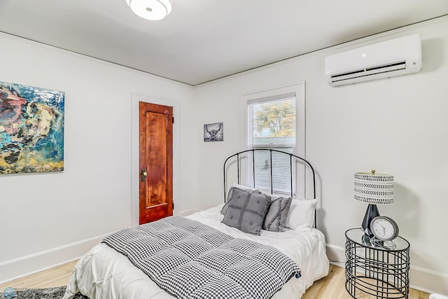 bedroom featuring a wall mounted AC and light hardwood / wood-style flooring