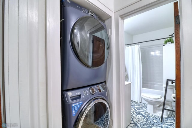 washroom featuring stacked washer / dryer and tile patterned flooring