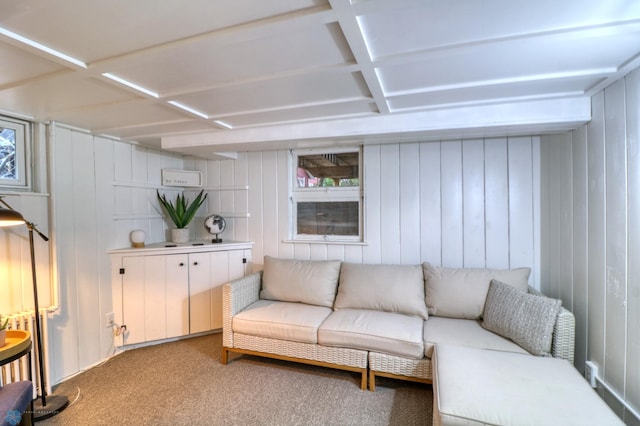 carpeted living room featuring beam ceiling, coffered ceiling, and wood walls