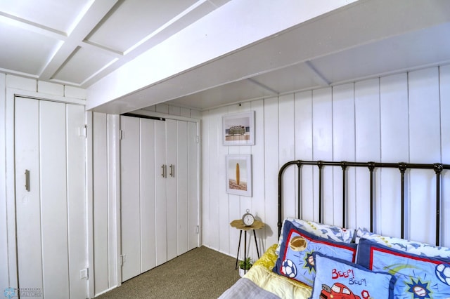 carpeted bedroom with wooden walls