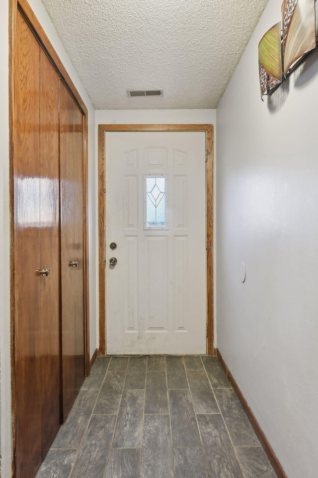 entryway featuring a textured ceiling and dark wood-type flooring