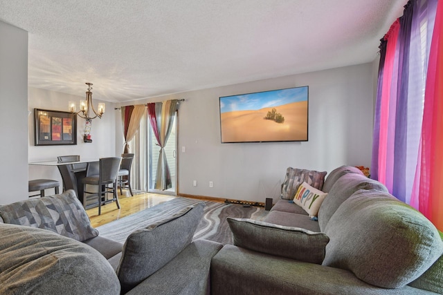 living room with hardwood / wood-style floors, a textured ceiling, and a notable chandelier