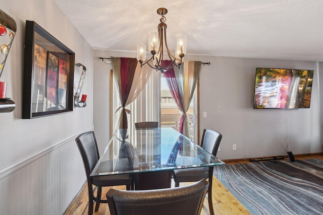 dining area featuring a chandelier, a textured ceiling, and hardwood / wood-style flooring