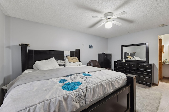 bedroom with ceiling fan, light hardwood / wood-style floors, and a textured ceiling