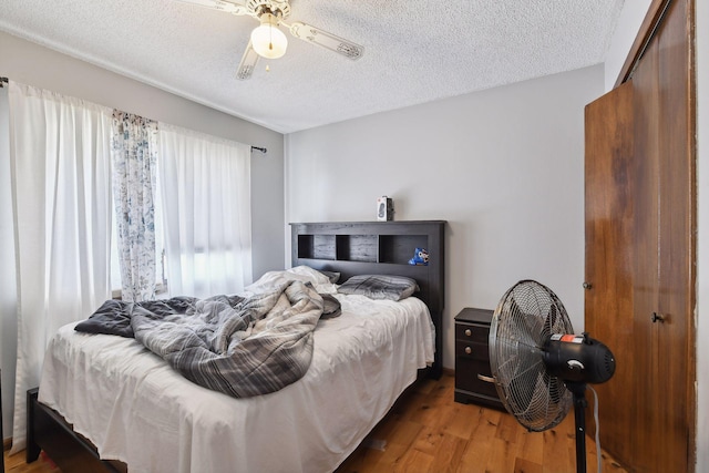 bedroom featuring ceiling fan, a textured ceiling, and hardwood / wood-style flooring