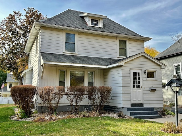 view of property with a front lawn and cooling unit