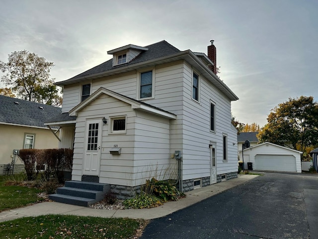 view of front of house featuring a garage and an outbuilding