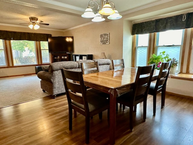 dining space with hardwood / wood-style floors, ceiling fan with notable chandelier, a textured ceiling, and crown molding