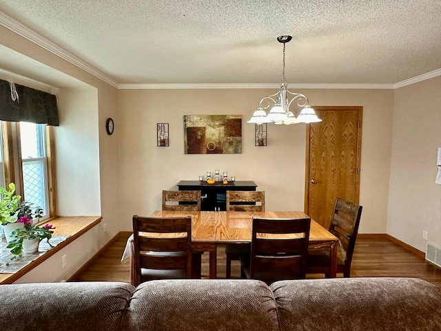 dining room with crown molding, hardwood / wood-style floors, a chandelier, and a textured ceiling