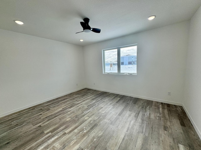 spare room featuring a textured ceiling, ceiling fan, and wood-type flooring